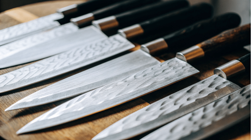 The image showcases a collection of Kotetsu knives, highlighting their sharp points and beautifully crafted blades, ideal for both professional chefs and home cooking enthusiasts. The design reflects Japan's rich history in knife making, combining cutting-edge technology and traditional craftsmanship for optimal performance in scoring vegetables and slicing meat.