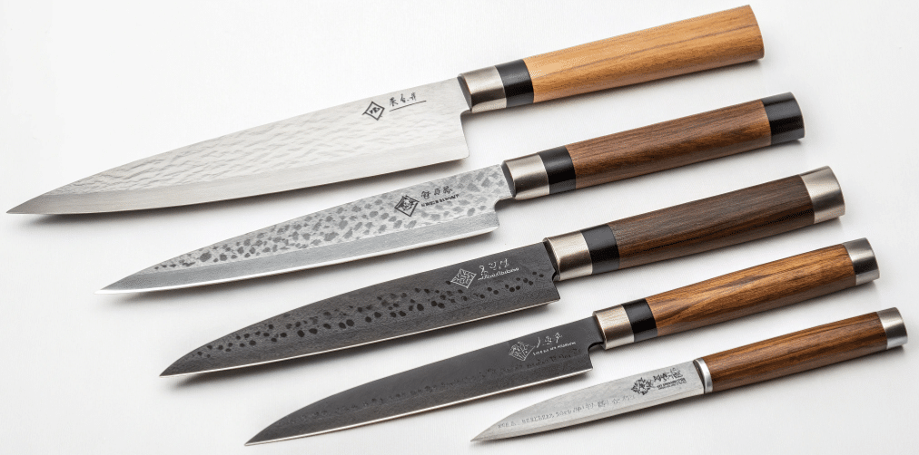 The image depicts a selection of honesuki knives, showcasing various blade lengths and materials, including both carbon steel and stainless steel options. Each knife features a unique triangular shaped blade designed for precise cuts, ideal for tasks like breaking down poultry and filleting fish, appealing to both home cooks and professional chefs.