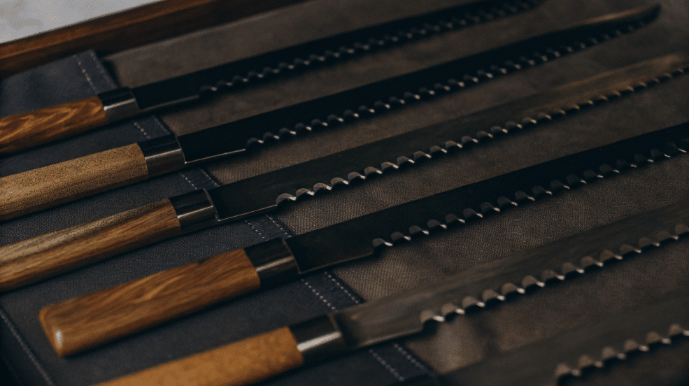 Variety of Bread Knives - Japanes Knives Tips The image showcases a variety of bread knives, including a serrated bread knife made from high carbon stainless steel, designed for slicing bread with hard crusts and soft interiors. The serrated edge allows for clean cuts and thin slices, making it a favorite among bakers for cutting loaves, sourdough, and even pastries.
