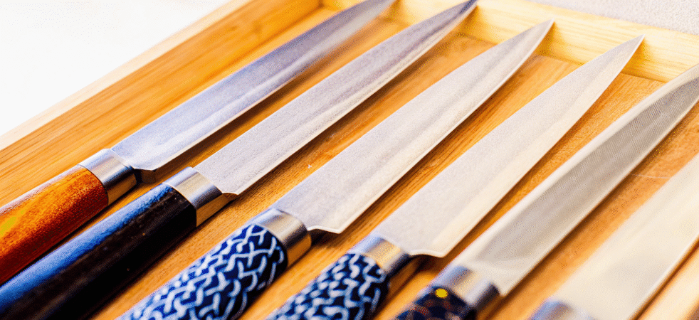 A closeup of Vegetable Knives lined up next to each other.