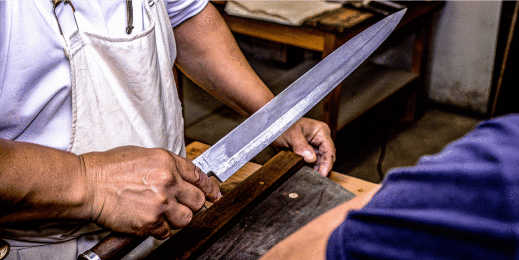 What Makes Sujihiki Knives Unique - Japanes Knives Tips The image showcases a beautifully crafted sujihiki knife, featuring a long, narrow blade made from high carbon stainless steel, ideal for precise slicing of meat and fish. Its pointed tip and razor-sharp edge highlight the knife's design, making it a popular choice among sushi chefs for creating paper-thin slices of sashimi.