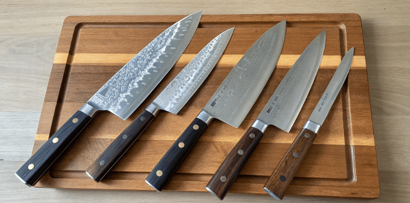 What Makes These Blades Special - Japanes Knives Tips The image showcases a collection of traditional Japanese knives, including a gyuto chef's knife and a yanagiba knife, arranged neatly on a wooden cutting board. Each knife features a razor sharp edge and slender blade, exemplifying the exceptional craftsmanship and precision required for various kitchen tasks like slicing raw fish and dicing vegetables.