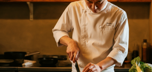 Man using a knife cutting on a chopping board.